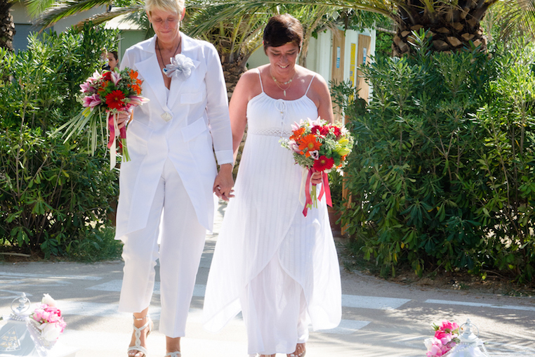 Gay couple walk down the aisle at a beach wedding in Italy