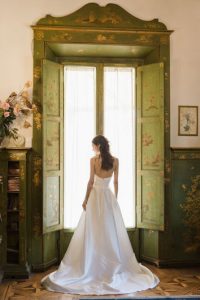 Bride standing in front of an antique window in a villa in Florence