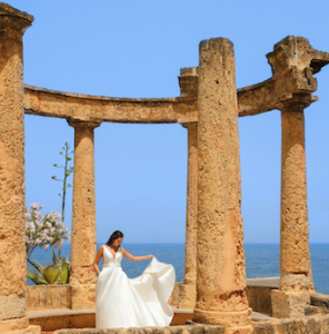 bride posing in a white wedding dress by a temple ruin at Villa Igiea in Sicily