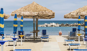 sunny beach with straw umbrella and sun loungers in Abruzzo