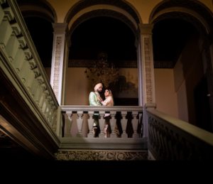 An Indian bride and groom pose for a photo on an elegant stairway inside Villa Castelletti in Florence. A beautiful Indian wedding venue.