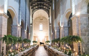 Wedding banquet set up in cavernous dining hall at large wedding venue in Italy.