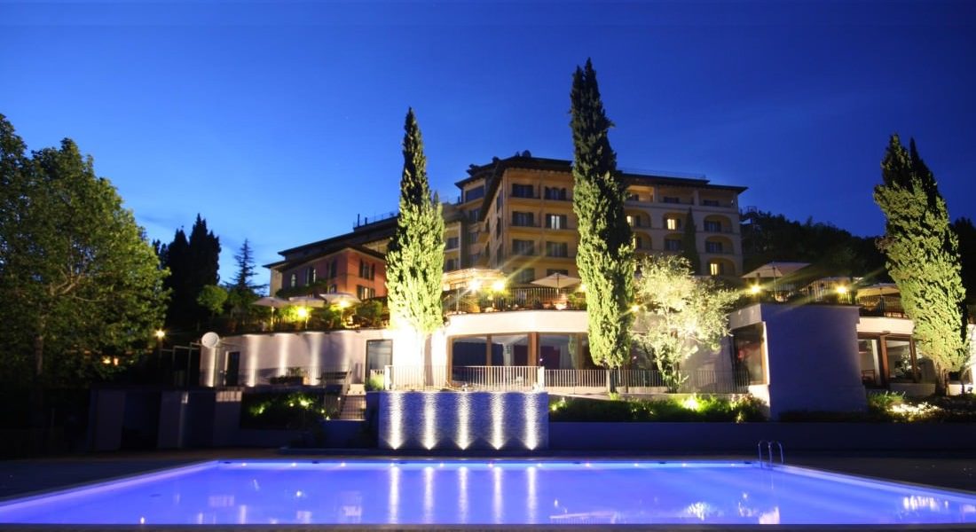 Inky blue night skies behind a large wedding venue in Tuscany with a pool in the foreground.