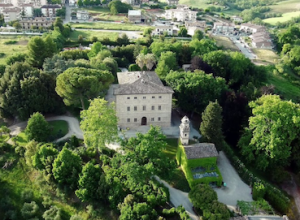 Antique villa in verdant green gardens viewed from the air.