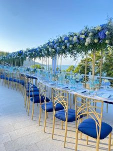 Elegant wedding banquet table setup on an outside terrace overlooking the sea. In Italy.